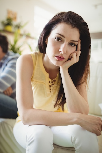 Upset couple ignoring each other on sofa