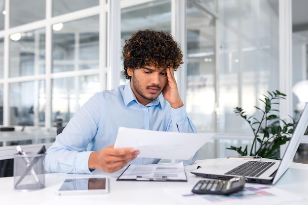 Upset financier looking at sales and revenue chart of company businessman inside office disappointed