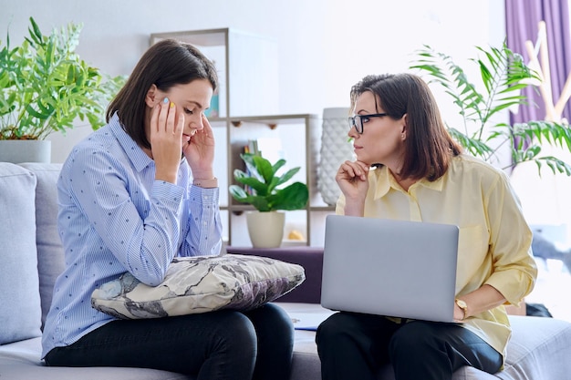 Upset sad young woman at session with psychologist