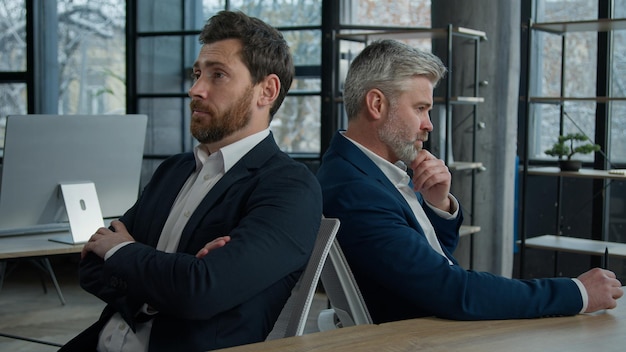 Upset shocked caucasian men businessmen partners employees sitting in office frustrated with