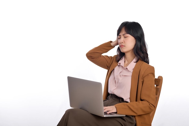 Upset young business asian woman While her using laptop sitting on wooden chair isolate on white background