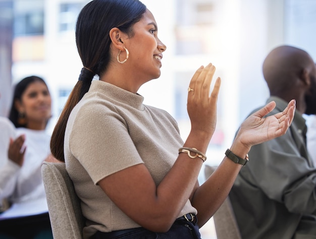 Upskilled and ready Shot of a young woman clapping hands in a meeting at work in a modern office