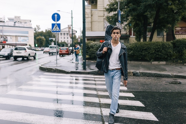 Urban fashion confident rock style man walking with guitar. Music lifestyle city life concept