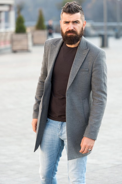 Urban fashion. Stylish casual outfit spring season. Menswear and male fashion concept. Man bearded hipster stylish fashionable coat or jacket. Comfortable outfit. Hipster fashion model outdoors.