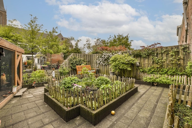 an urban garden with lots of plants and flowers in the middle part of the yard surrounded by wooden fences