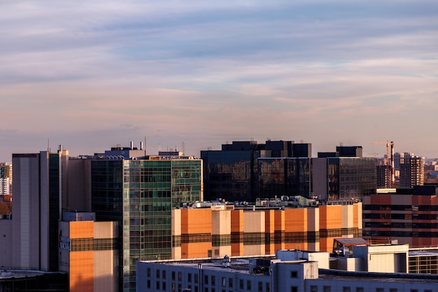 Urban industrial landscape in the evening at sunset. Beautiful blue sky, creative business buildings and residential buildings.