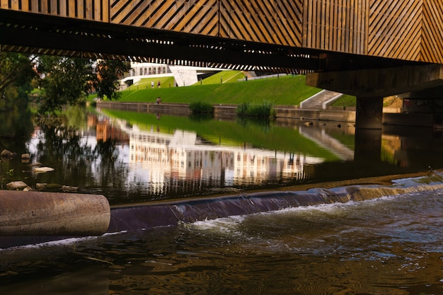 Urban landscape with a view of a small river flowing under the bridge