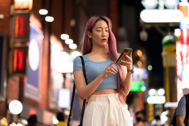 Urban portrait of young woman with long pink hair