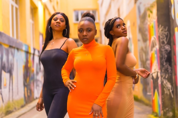 Urban style fashion with three black African girls on a city street