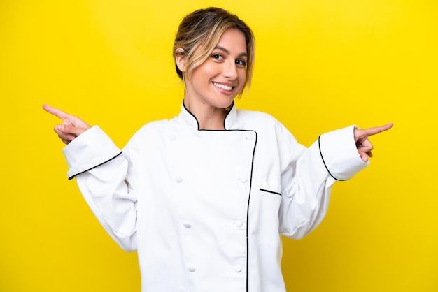 Uruguayan chef woman isolated on yellow background pointing finger to the laterals and happy