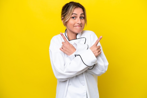 Uruguayan chef woman isolated on yellow background pointing to the laterals having doubts