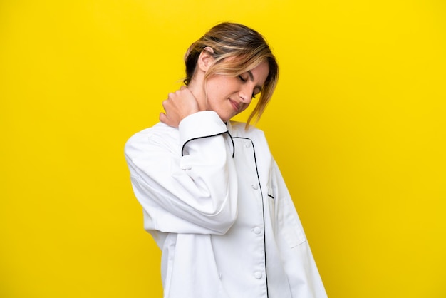 Uruguayan chef woman isolated on yellow background with neckache