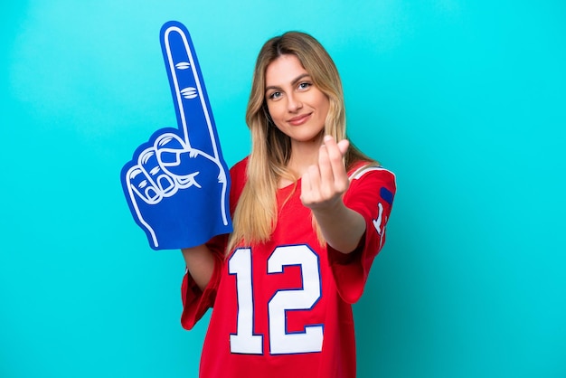 Uruguayan sports fan woman isolated on blue background making money gesture