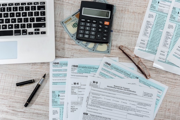 Us 1040 tax form with pen, dollar and laptop at office. tax time. accounting concept