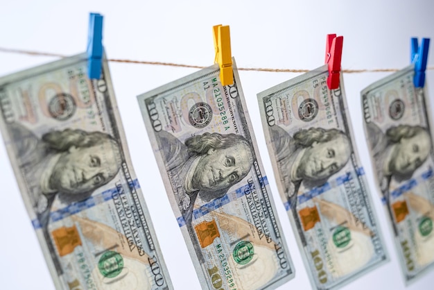 US dollar banknotes hanging on rope with wooden clothespins