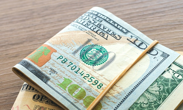 US dollar bills on wooden furniture in closeup photography