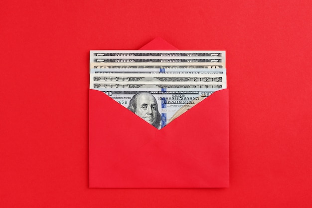 US dollars in cash in red envelope on minimal style background