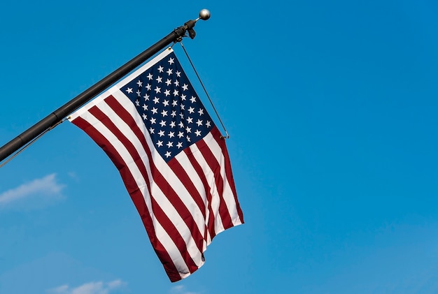 USA flag, American flag on flagpole against blue sky