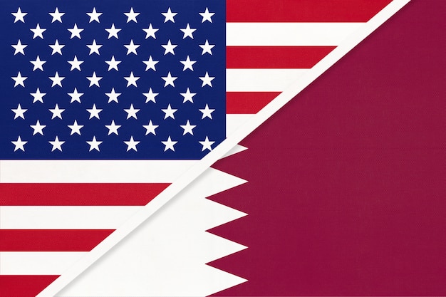 USA vs Qatar national flag from textile. Relationship between two american and asian countries.