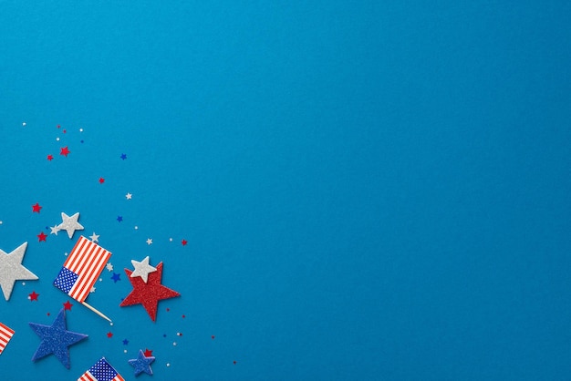 USAs Independence Day celebration depicted with glitter stars confetti and national flag Top view on a blue background with an empty space for text or advertisement