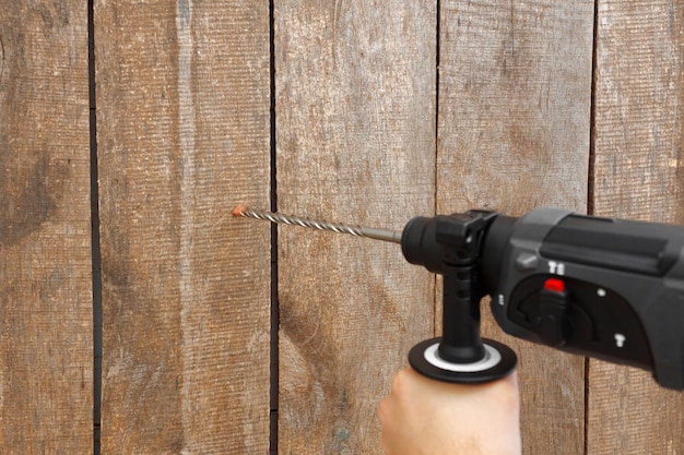 Photo use hammer drill to drill the wall