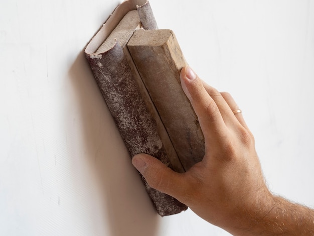 Use sandpaper to sand the wall surface. Surface leveling, work inside the house.