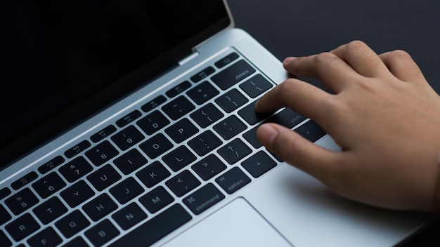 Use your hand to touch the keyboard keys on the laptop