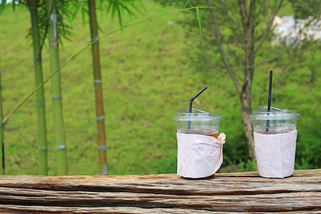 A used plastic drink cups is placed on a wooden chair in the garden