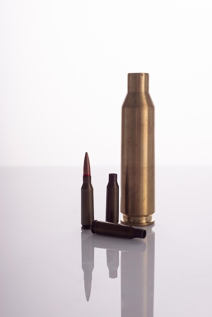 Used spent shells of cartridges from a machine gun and a machine gun on a white background