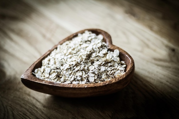 Useful oat flakes in a wooden bowl