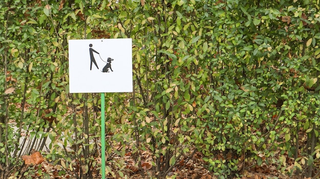 A useful reminder is to enter the dog park. Keep dogs on a leash warning sign in a park. A clean symbol of dog food in the park for a clean environment and clean society.