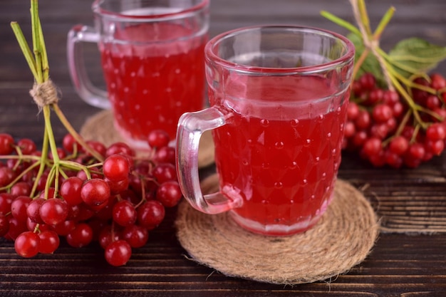 Useful tea from viburnum berries and on a dark wooden background.