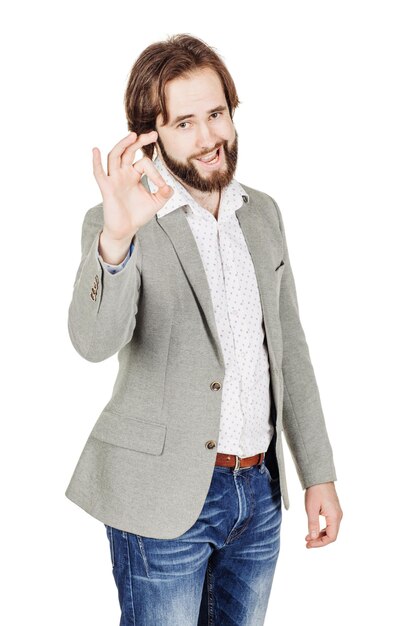 Usinessman looking at camera and showing OK while standing against white background