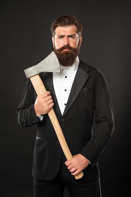 Using axe in place of straight razor Bearded man in suit hold axe Barbershop Barbering