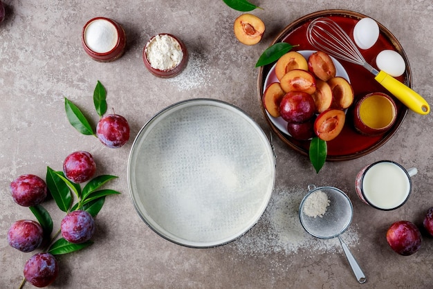 Using eggs whisk plum and a baking pan are used in the baking process