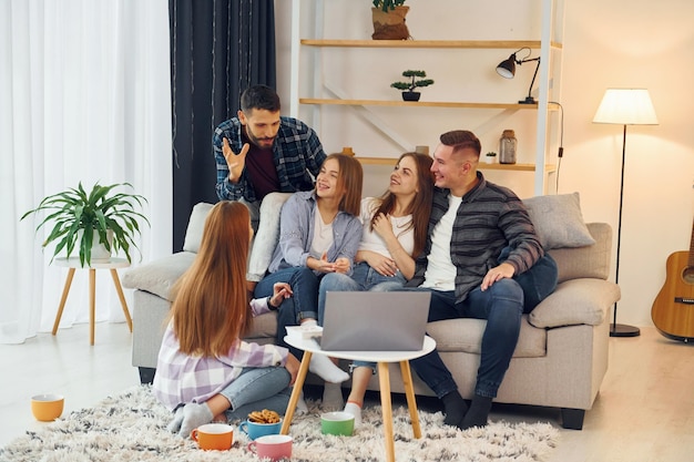 Using laptop Group of friends have party indoors together