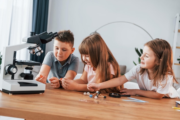 Using microscope Kids having fun in the domestic room at daytime together