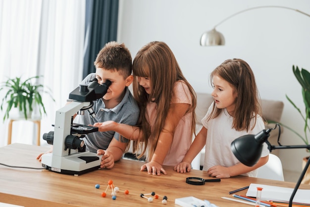 Using microscope Kids having fun in the domestic room at daytime together