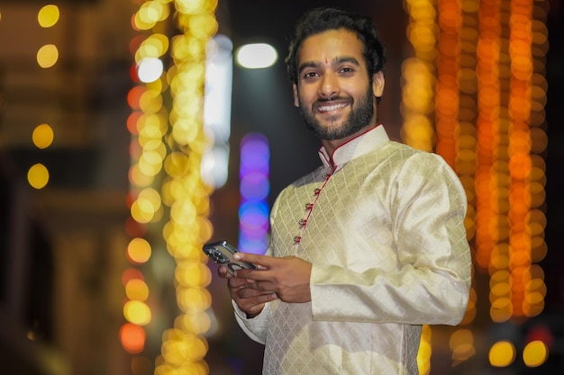 Using mobile Young Boy in night image wearing traditional dress and beautiful background