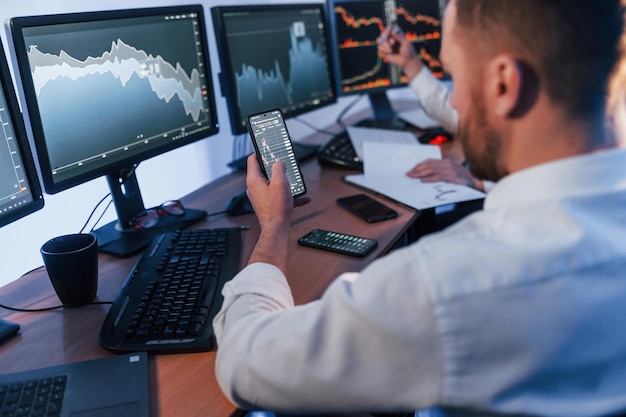 Using the phone Two stock traders working in the office with exchange technology