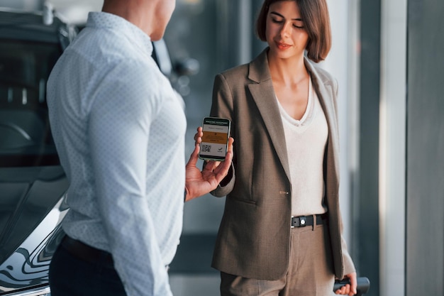 Using smartphone Woman showing her vaccine passport to the man