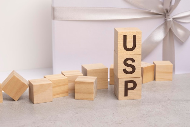 Usp letters on wooden cubes concept on light gift box background business as usual concept image space for text in right front view usp short for Unique Selling Proposition