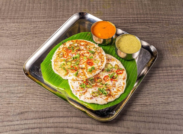 Uthappam Oothappam topped with onion carrots served with Chutney top view