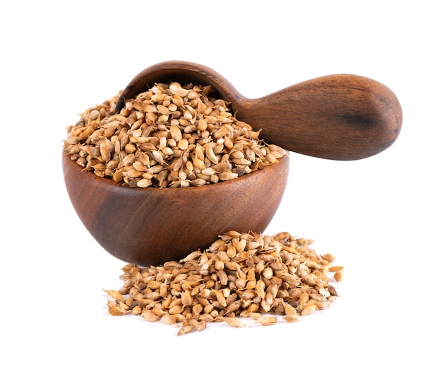 Utsho suneli seeds in wooden bowl and spoon isolated on white background Trigonella caerulea or blue fenugreek