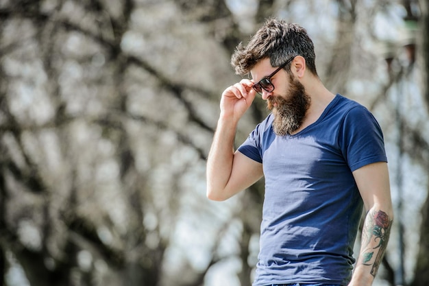 UV filter Bearded hipster brutal man wear protective sunglasses Man bearded with sunglasses nature background Hipster confident in dark sunglasses Bearded man wear modern fashionable sunglasses