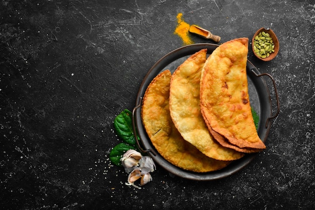 Uzbek eastern Tatar cuisine cheburek with meat and suluguni cheese Top view Traditional dish of Turkish and Mongolian Free copy space