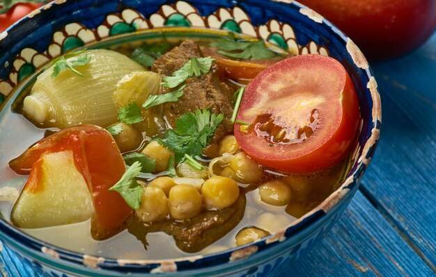 Uzbek nahot shurpa , soup with vegetables and chickpeas, Top view.  Central Asian cuisine