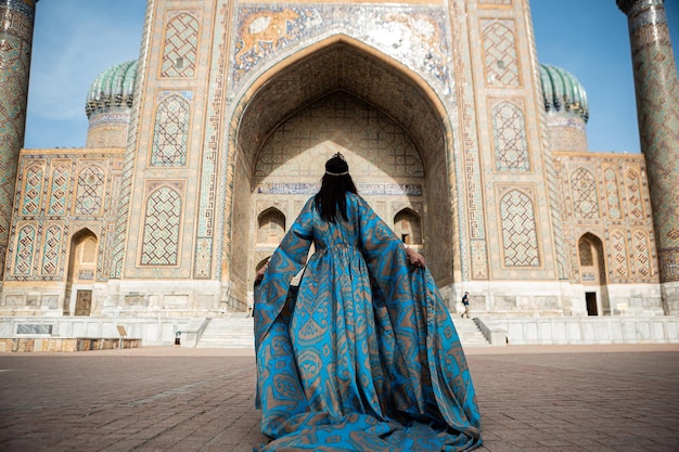 Uzbek woman in traditional dress in Registan square Samarkand Uzbekistan