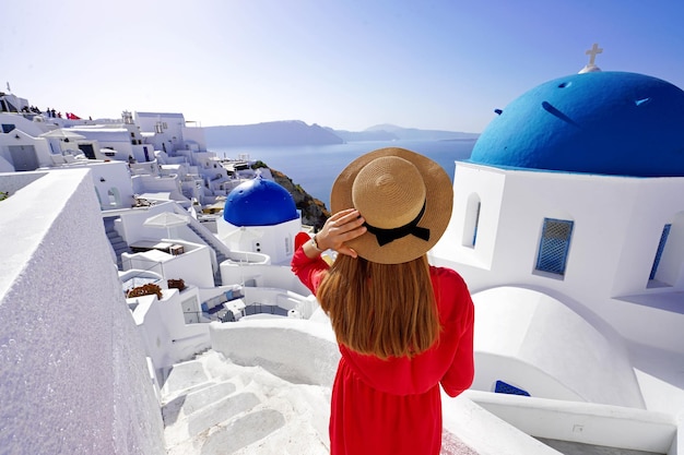 Vacation in Greece Beautiful tourist girl enjoying panoramic view of Santorini Wide angle