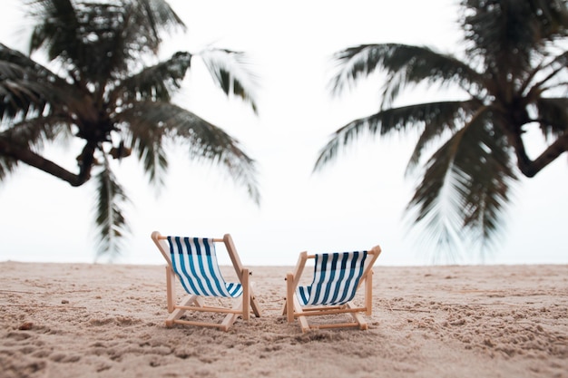 Vacation holidays background wallpaper two beach lounge chairs under coconut tree on the beach